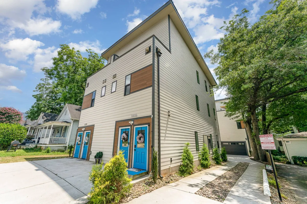 This image showcases the vibrant exterior of the property, featuring bright blue doors, modern architecture, and a landscaped pathway. The inviting entryway hints at the energy and style awaiting inside, and the pathway suggests a direct connection to the surrounding Uptown neighborhood.
